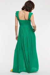 woman wearing a green maxi dress with ruffled sleeves and a smocked bodice, viewed from the back