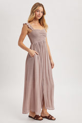 woman wearing a mauve maxi dress with ruffle straps, smocked bodice, and pockets