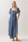 woman wearing a denim maxi dress with a square neckline, puff sleeves, and side pockets