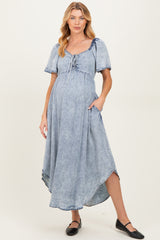 woman wearing a light blue maternity dress with short sleeves and drawstring detail, showing her baby bump