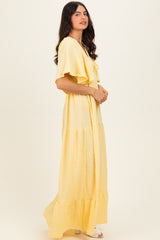 woman wearing a yellow tiered maxi dress with ruffle details and short sleeves