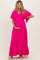 woman wearing a bright pink maternity maxi dress with a tie-front and layered sleeves, highlighting her baby bump