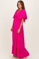 woman wearing a bright pink maxi dress with flutter sleeves and a tiered bottom