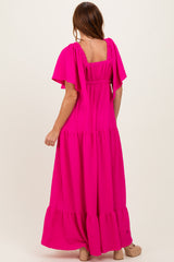 woman wearing a vibrant pink maxi dress with flutter sleeves and tiered hem, shown from the back