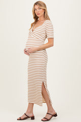 woman wearing a beige and white striped maternity dress with short sleeves and a side slit, holding her baby bump