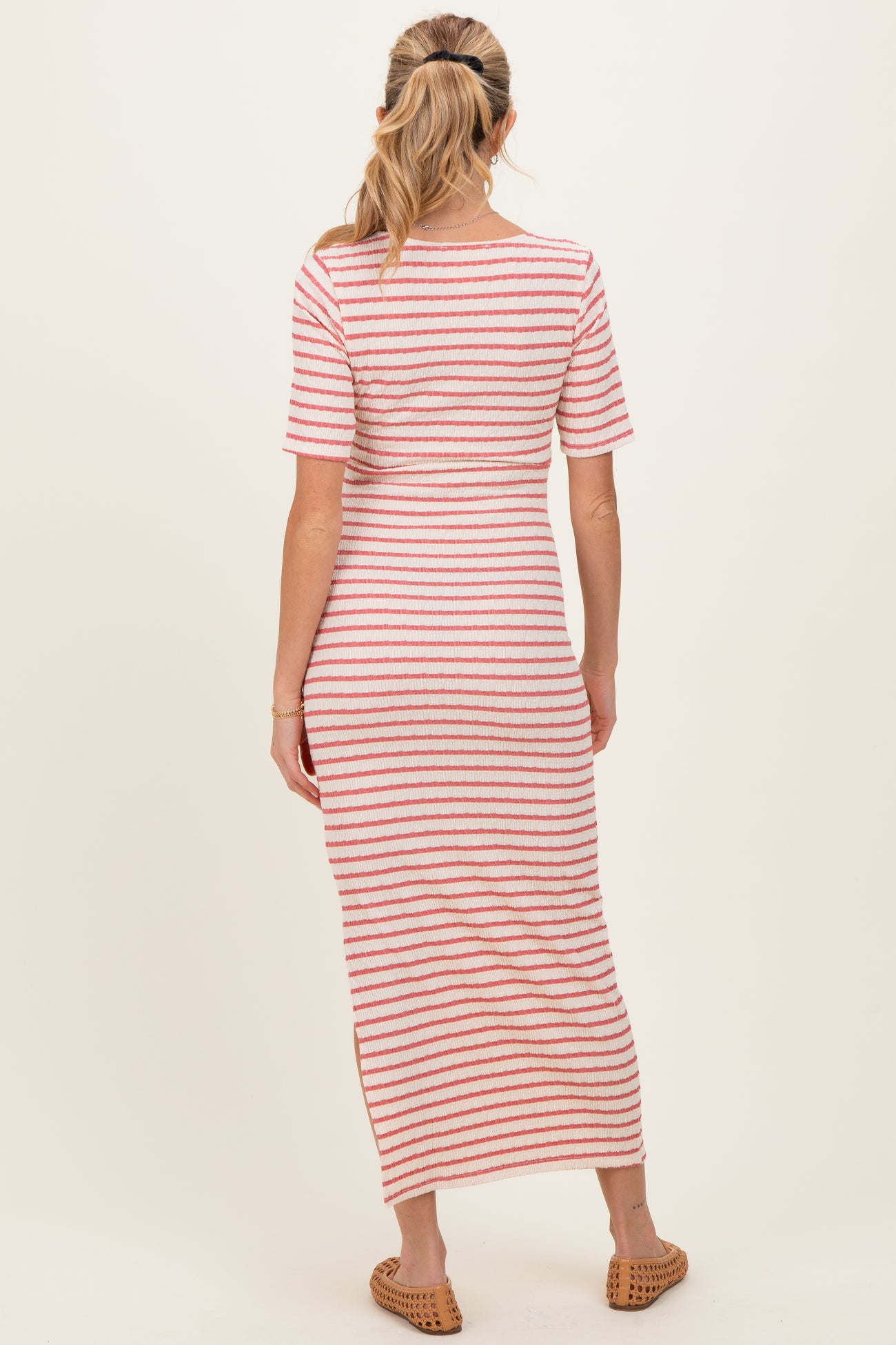 woman wearing a striped maternity maxi dress with short sleeves and a relaxed fit, showcasing a baby bump from the back