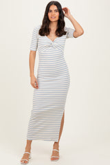 woman wearing a striped midi dress with a twist detail and side slit, posing with one hand on her head