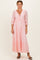 woman wearing a pink lace maxi dress with three-quarter sleeves and a tie-front neckline
