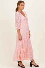 woman wearing a pink lace maxi dress with a tie front detail and long puff sleeves