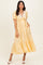 woman wearing a yellow polka dot midi dress with puff sleeves and a v-neckline tie detail