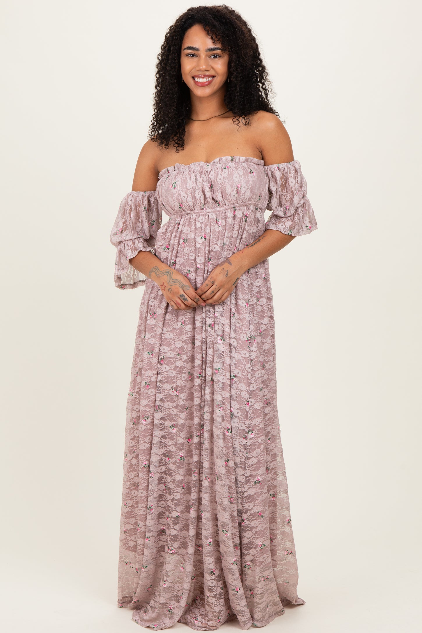 woman wearing a pink off-shoulder maxi dress with puff sleeves and a floral pattern
