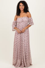 woman wearing a pink off-shoulder maxi dress with puff sleeves and a floral pattern