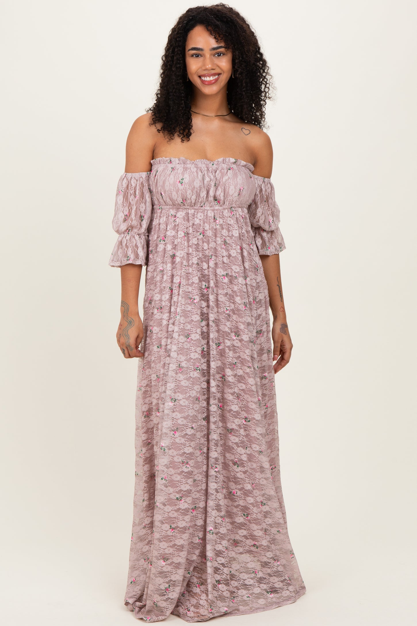 woman wearing a pink off-the-shoulder maxi dress with puff sleeves and floral pattern