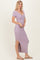 woman wearing a lavender short sleeve maxi dress with a v-neckline and side slit