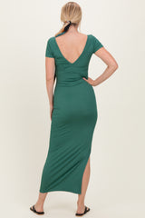 woman wearing a green v-neck maxi dress with short sleeves and a side slit, seen from the back