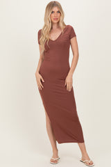 woman wearing a brown short sleeve form-fitting maxi dress with a side slit