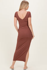 woman wearing a brown fitted maxi dress with short sleeves and a low back design