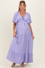 woman wearing a lavender maternity maxi dress with a tie front and tiered ruffles, showcasing her baby bump