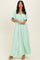 woman wearing a mint green tiered maxi dress with short flutter sleeves and a tie-front detail