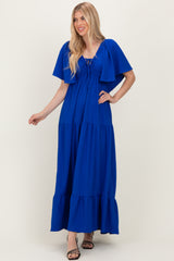 woman wearing a bright blue tiered maxi dress with flutter sleeves and drawstring neckline