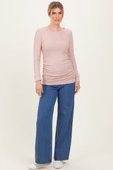 woman wearing a light pink ribbed long sleeve top with side ruching and wide leg denim jeans