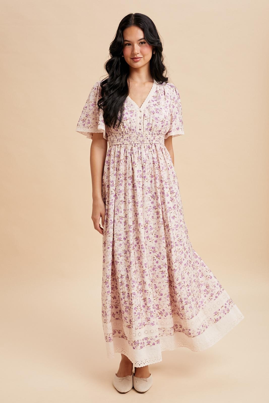 woman wearing a floral print maxi dress with short sleeves and a smocked waist