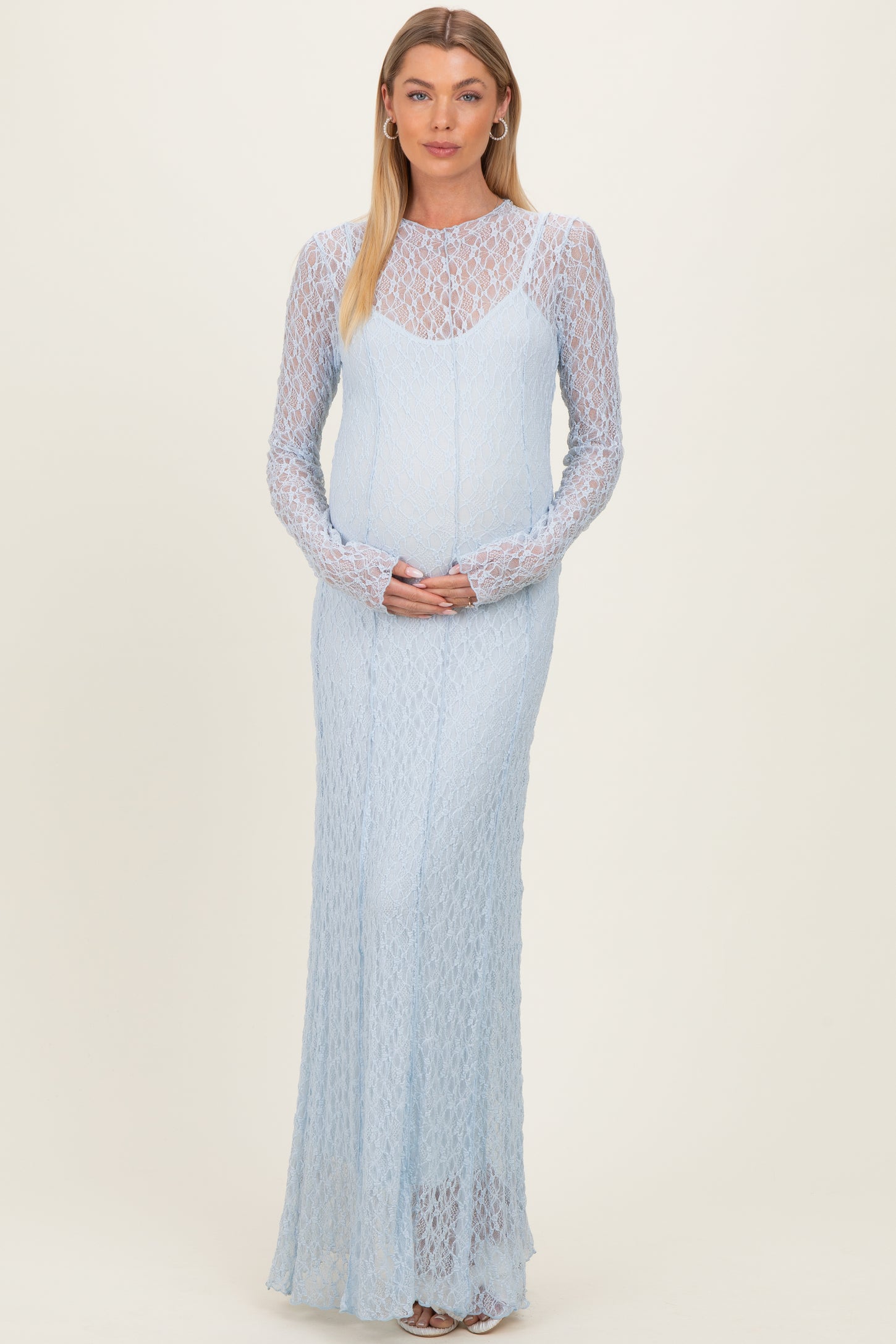 woman wearing a light blue long sleeve maternity dress with a textured design and a visible baby bump