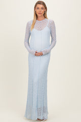 woman wearing a light blue long sleeve maternity dress with a textured design and a visible baby bump
