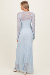woman wearing a light blue long sleeve maternity dress with intricate lace detailing and a flowy fit