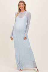 woman wearing a light blue lace maternity gown with long sleeves and a visible baby bump