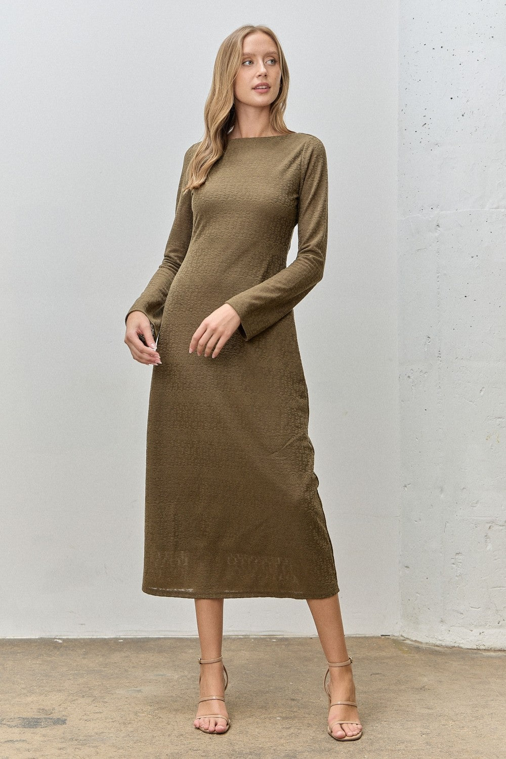 woman wearing a long sleeve olive green midi dress with a fitted silhouette and a high neckline