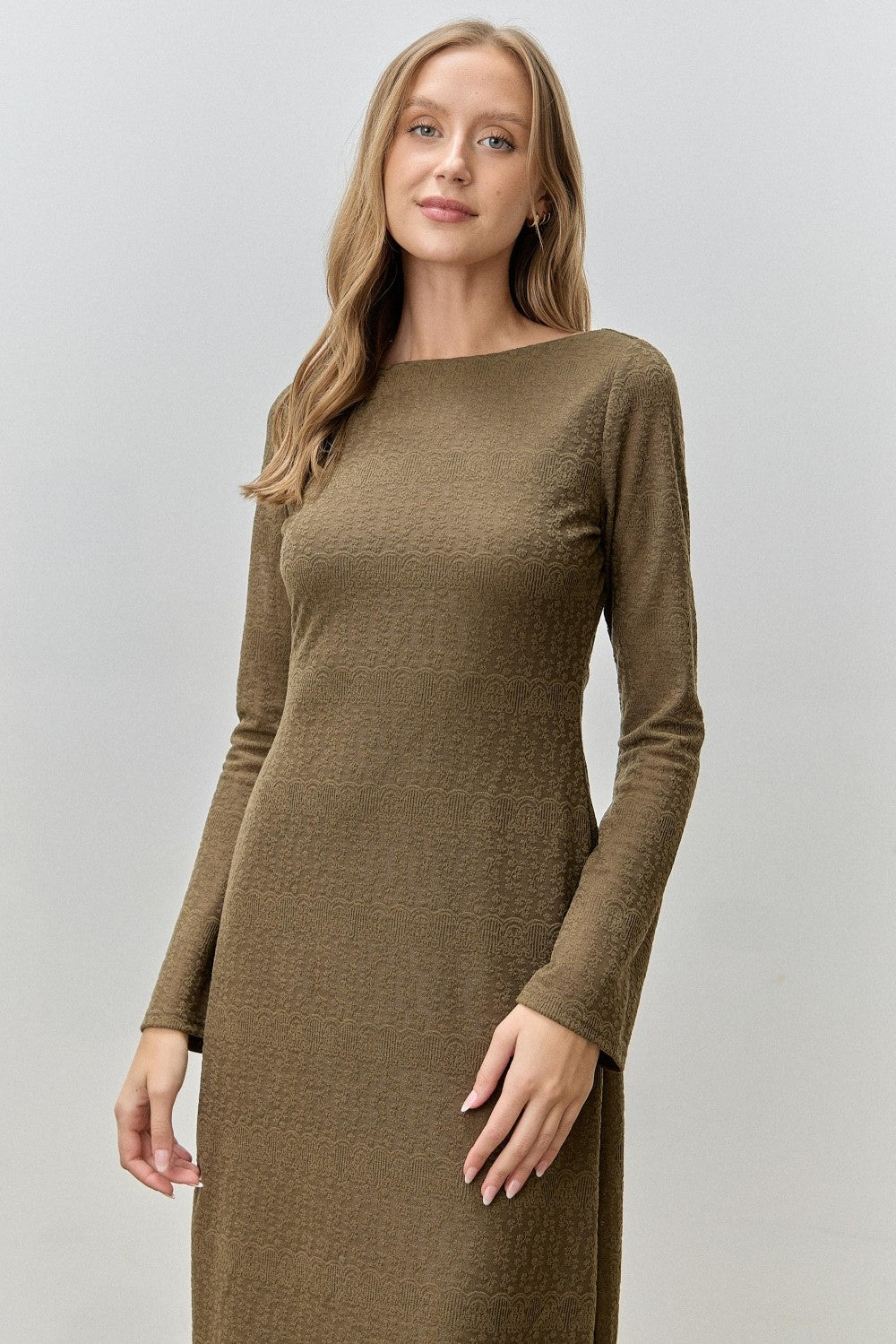 woman wearing a long sleeve olive green textured dress with a straight silhouette