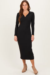 woman wearing a black long sleeve ribbed midi dress with a collar and high slit, standing in a neutral background