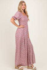 woman wearing a lilac floral maxi dress with puff sleeves and a fitted bodice, standing in profile