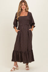 woman wearing a brown floral maternity dress with square neckline and puff sleeves, featuring pockets and a ruffled hem