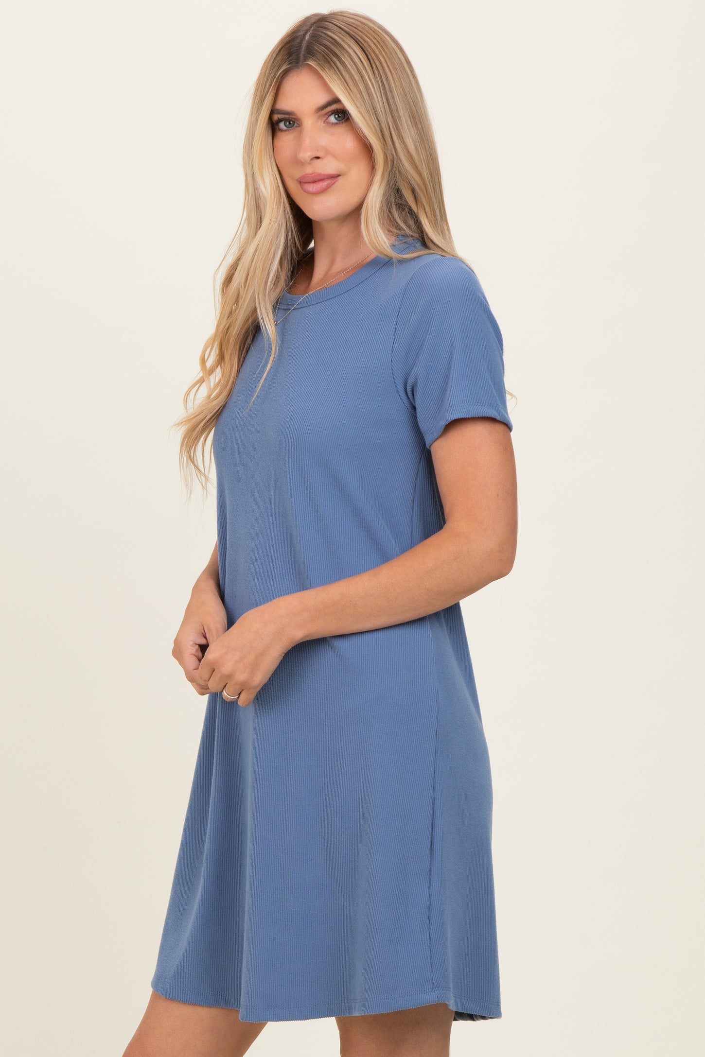 woman wearing a light blue short sleeve ribbed dress with a relaxed fit and side slits