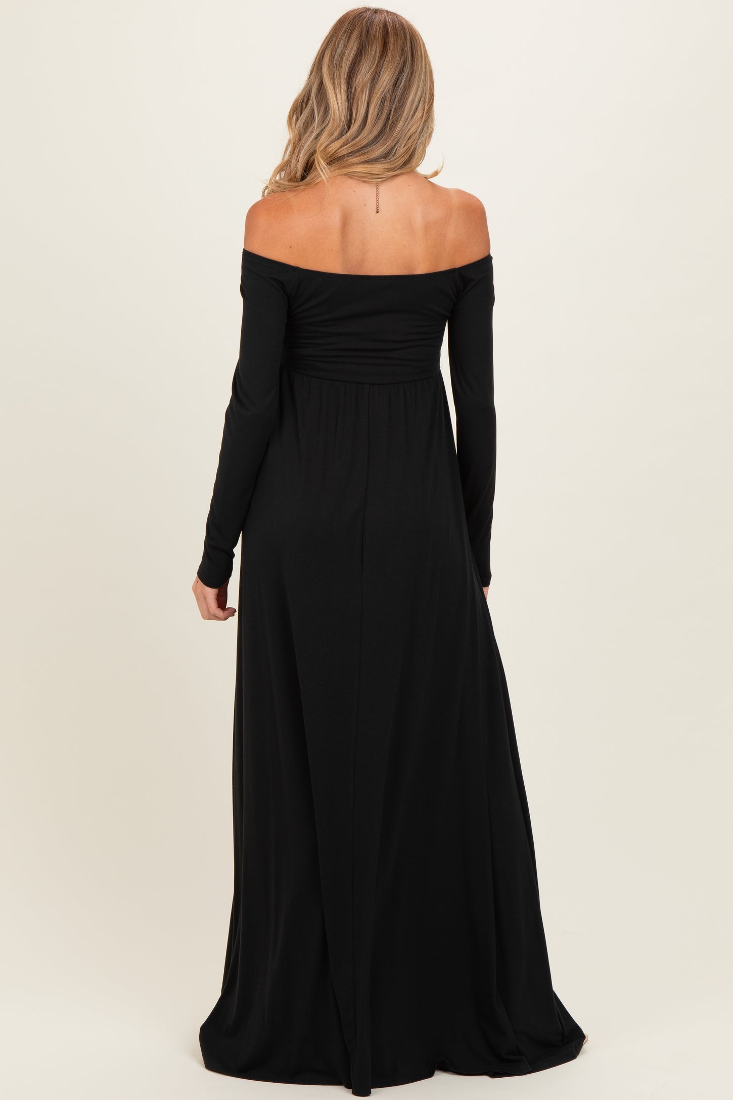 maternity wear off the shoulder black maxi dress with long sleeves and a flowing skirt, shown from the back