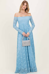 woman wearing a light blue off-the-shoulder lace maxi dress and holding a small handbag