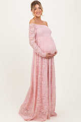 woman wearing a pink lace off-the-shoulder maternity gown and holding her baby bump