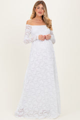 woman wearing a white off-the-shoulder long sleeve lace maternity dress with a flowing skirt and a relaxed fit