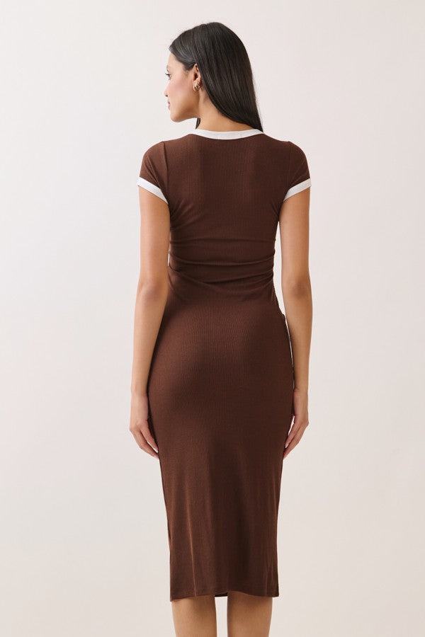 woman wearing a brown fitted dress with short sleeves and a white trim, showing the back view