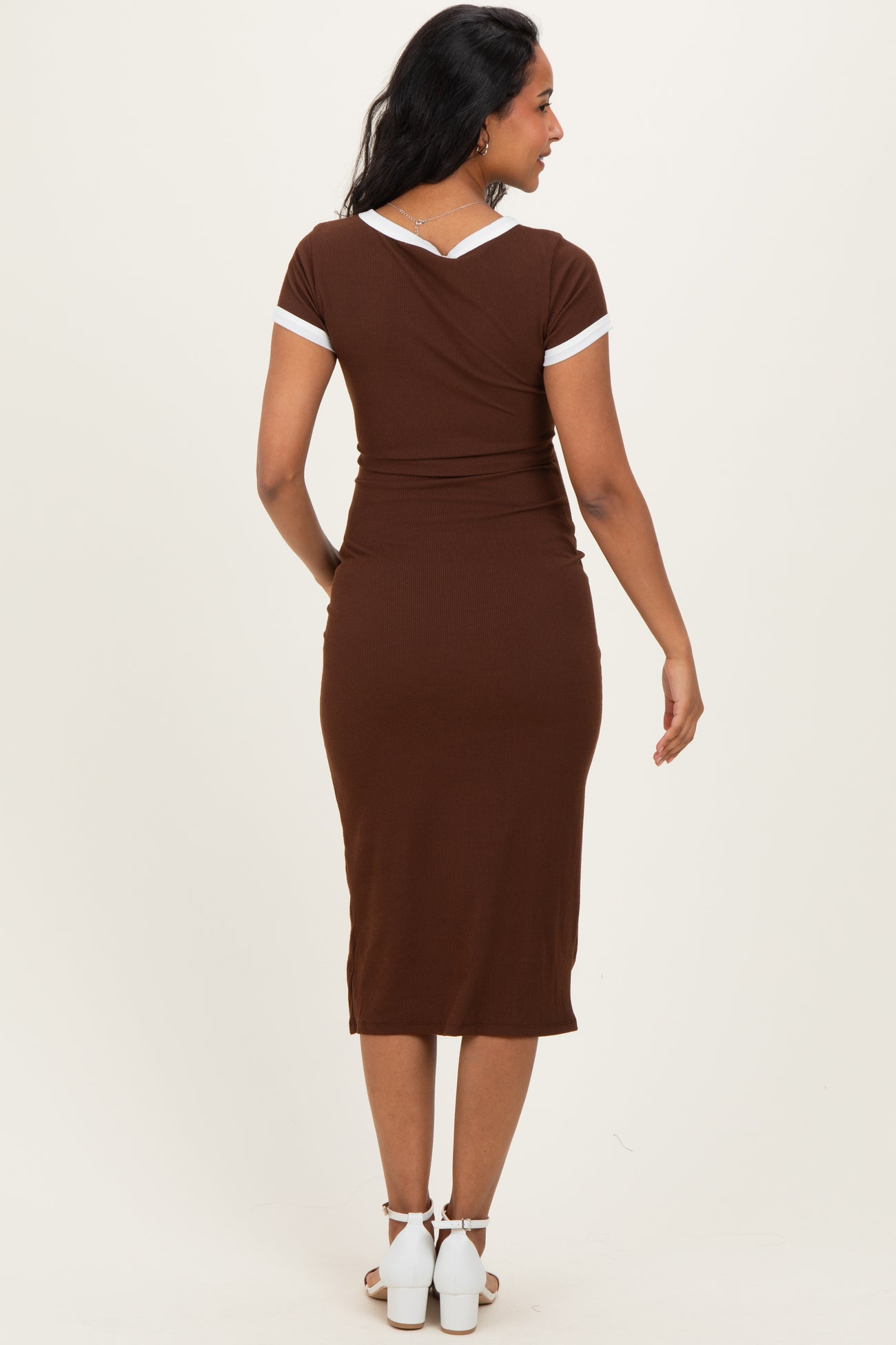 maternity wear brown ribbed dress with white trim details, worn by a model showing a baby bump from the back