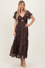 woman wearing a dark floral maxi dress with short ruffled sleeves and a front cut-out detail