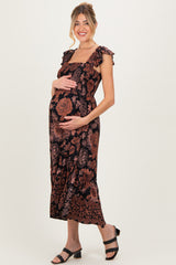 woman wearing a black floral maternity dress with ruffled straps and a visible baby bump