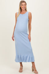 woman wearing a light blue ribbed maternity maxi dress with a ruffled hem and a visible baby bump