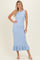 woman wearing a light blue ribbed midi dress with a ruffled hem and sleeveless design