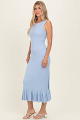 woman wearing a light blue ribbed midi dress with a ruffled hem and styled with white sandals