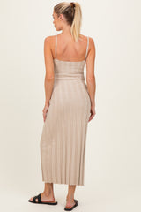 woman wearing a beige ribbed maternity dress with adjustable straps, showing a fitted silhouette and mid-calf length