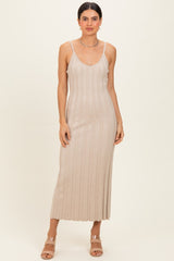 woman wearing a beige ribbed maxi dress with thin straps and a fitted silhouette