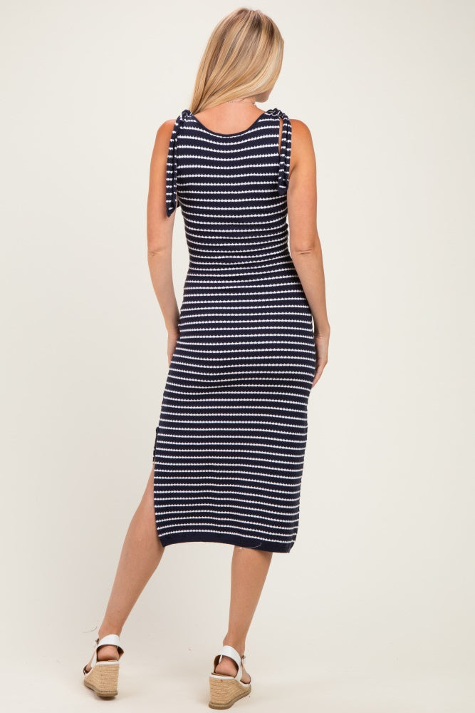 woman wearing a navy and white striped midi dress with bow tie straps and a side slit